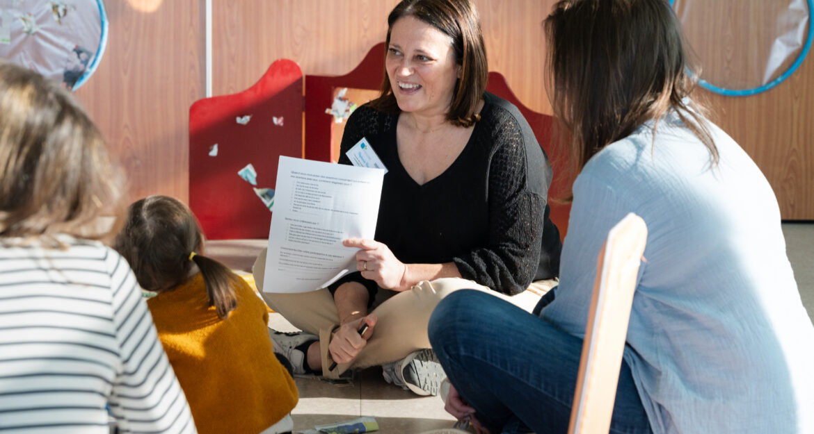 Une professionnelle de la petite enfance échange avec des parents et des enfants lors d’un atelier organisé par la Communauté de communes Lyons Andelle.
