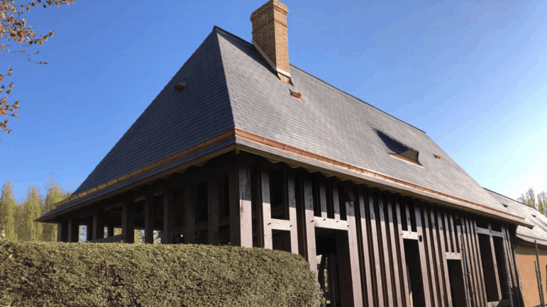 Travaux de couverture en ardoise au clou sur un bâtiment traditionnel à Renneville.