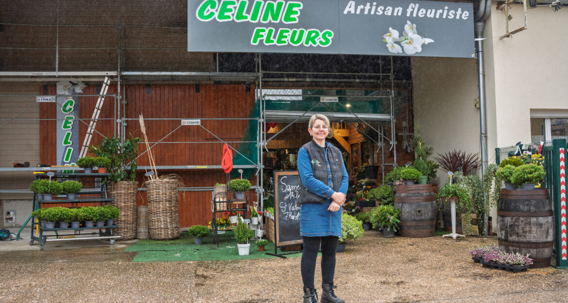Céline, fleuriste à Vascœuil dans l'Eure, pose devant son magasin dont la façade est en cours de réfection.