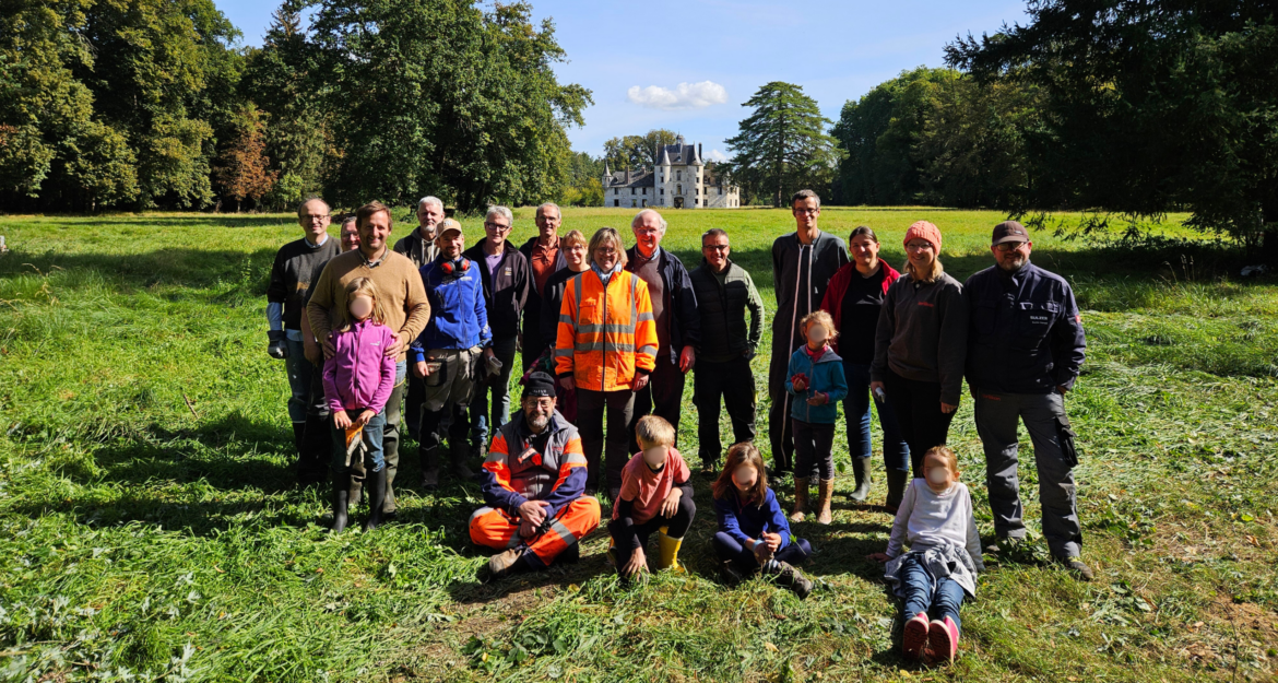 Bénévoles de l'association des Amis du château de Pont-Saint-Pierre réunis dans le parc, le château en arrière-plan