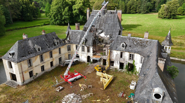Vue aérienne du château de Logempré à Pont-Saint-Pierre en travaux, avec une grue et des éléments de charpente dans la cour